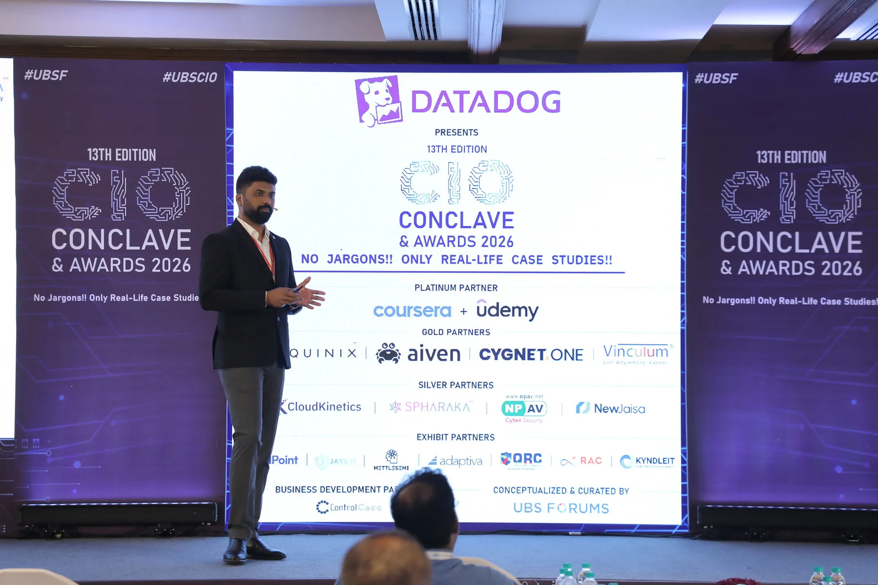 A Spharaka speaker presenting on stage at the 13th CIO Conclave and Awards 2026, in front of the event partner slide.