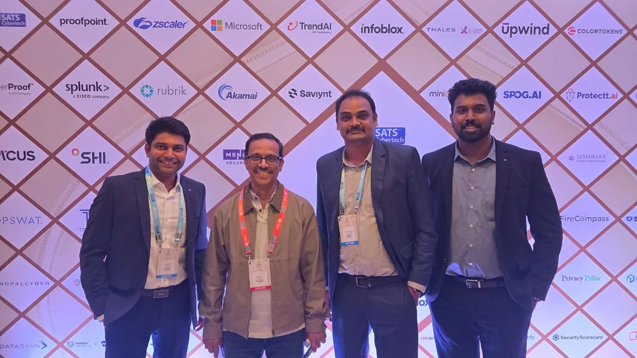 Four people in front of a CISO summit sponsor wall carrying the logos of the participating security vendors, including Spharaka.