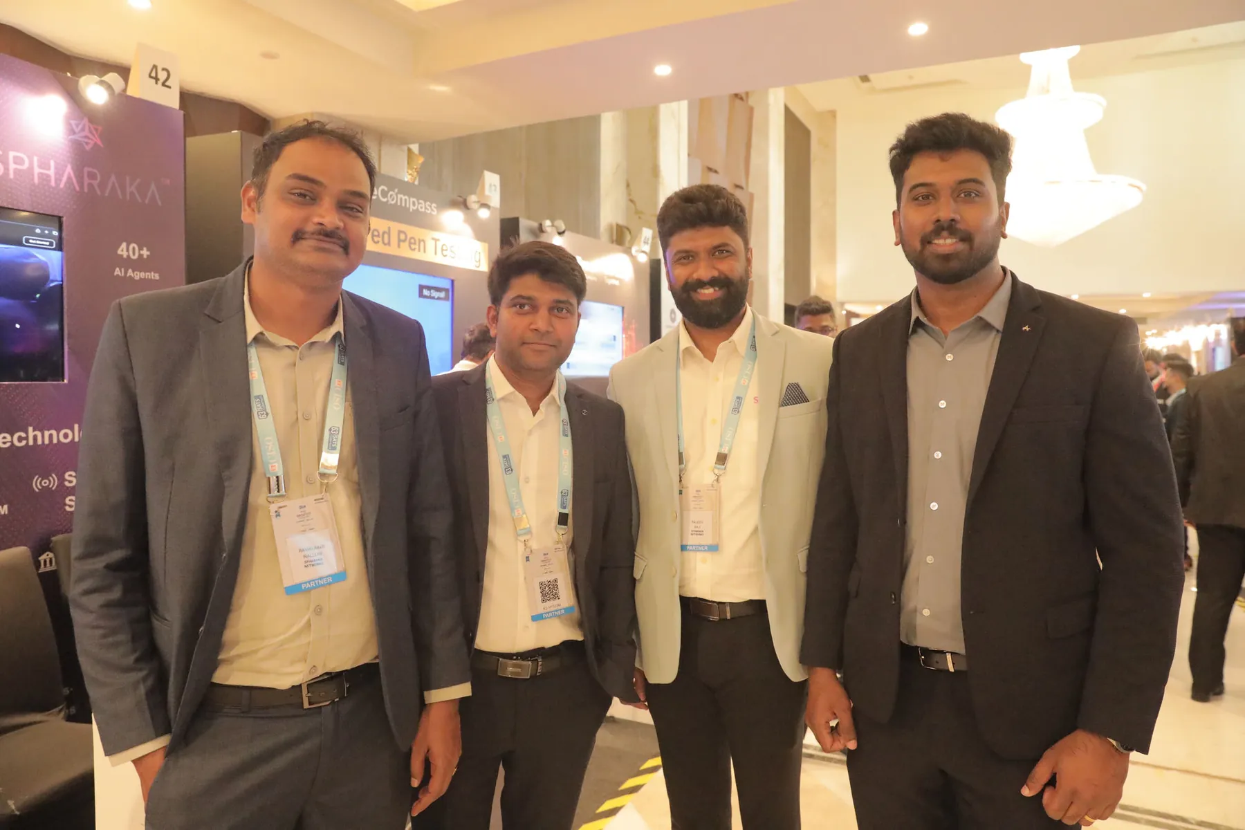 Four members of the Spharaka Networks team standing together in front of the company's exhibition stand at a CISO summit.
