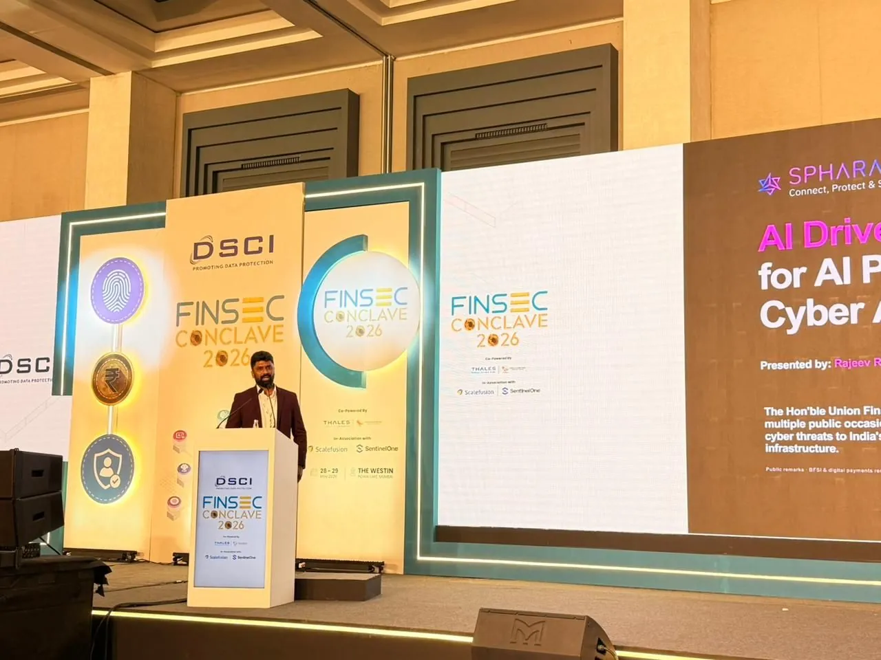 A Spharaka speaker at the podium of the DSCI FINSEC Conclave 2026, with the session title slide on the screen beside them.